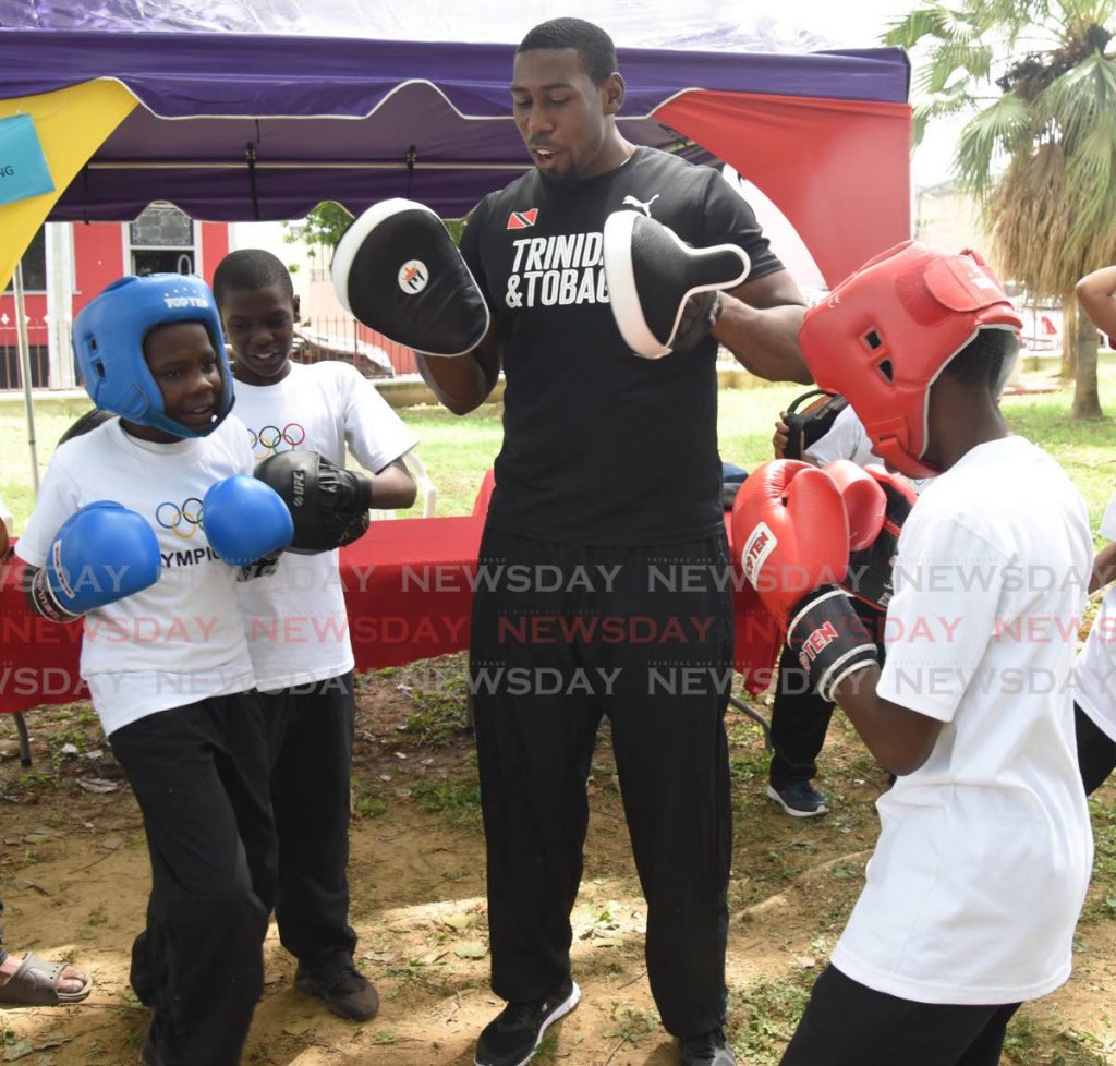 In this June 21, 2019 file photo, TT boxer Nigel Paul teaches boxing techniques to two boys during Olympic Day 2019 at Lord Harris Square, Port of Spain. - In this June 21, 2019 file photo, TT boxer Nigel Paul teaches boxing techniques to two boys during Olympic Day 2019 at Lord Harris Square, Port of Spain. -