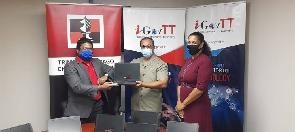 iGovTT acting deputy CEO Sherwin Ragoonanan, left, presents acting Supt. of Prisons Allan Nanan with ten laptops for prisoners' use at the Inter-Continental Chess Championships next week. At right is local chess association president Sonja Johnson. - TTCA iGovTT acting deputy CEO Sherwin Ragoonanan, left, presents acting Supt. of Prisons Allan Nanan with ten laptops for prisoners' use at the Inter-Continental Chess Championships next week. At right is local chess association president Sonja Johnson. - TTCA