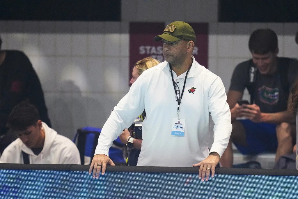 FILE - Coach Anthony Nesty watches as swimmers warm up at the U.S. nationals swimming meet in Indianapolis, June 27, 2023. Nesty made more history Thursday, Sept. 21, when he was picked to lead the U.S. men’s swimming team in Paris, where he will become the first Black head coach for the powerhouse American squad at the Olympics. Nesty’s selection was announced by USA Swimming, which also appointed Todd DeSorbo to head the women’s squad next summer. (AP Photo/Michael Conroy, File) (Image obtained at tt.loopnews.com) FILE - Coach Anthony Nesty watches as swimmers warm up at the U.S. nationals swimming meet in Indianapolis, June 27, 2023. Nesty made more history Thursday, Sept. 21, when he was picked to lead the U.S. men’s swimming team in Paris, where he will become the first Black head coach for the powerhouse American squad at the Olympics. Nesty’s selection was announced by USA Swimming, which also appointed Todd DeSorbo to head the women’s squad next summer. (AP Photo/Michael Conroy, File) (Image obtained at tt.loopnews.com)