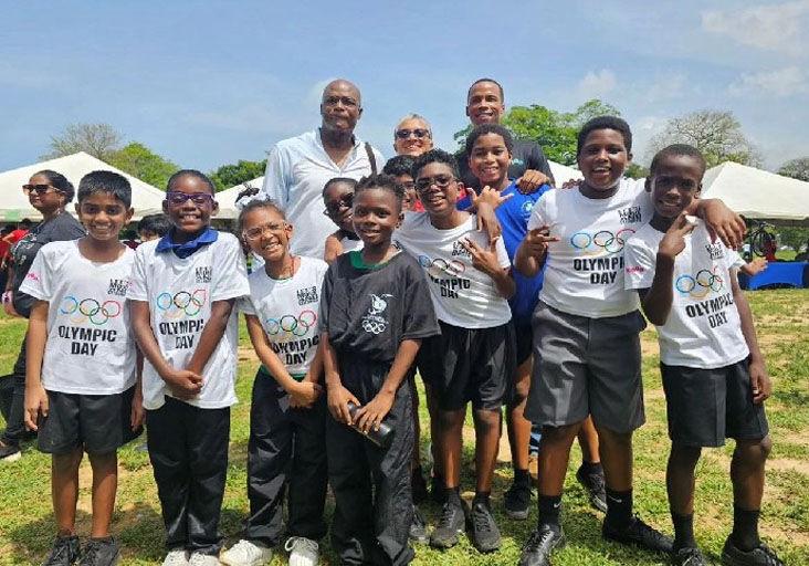 INSPIRING THE NEXT GENERATION: Trinidad and Tobago’s first Olympic gold medallist Hasely Crawford (left, back row), TTOC president Diane Henderson and Kanoo’s Zwede Hewitt pose with a group of children at the TTOC Olympic Day display of sports at the Queen’s Park Savannah, in Port of Spain, on Friday. Kanoo sponsored 300 Olympic Day jerseys for children. (Image obtained at trinidadexpress.com) INSPIRING THE NEXT GENERATION: Trinidad and Tobago’s first Olympic gold medallist Hasely Crawford (left, back row), TTOC president Diane Henderson and Kanoo’s Zwede Hewitt pose with a group of children at the TTOC Olympic Day display of sports at the Queen’s Park Savannah, in Port of Spain, on Friday. Kanoo sponsored 300 Olympic Day jerseys for children. (Image obtained at trinidadexpress.com)