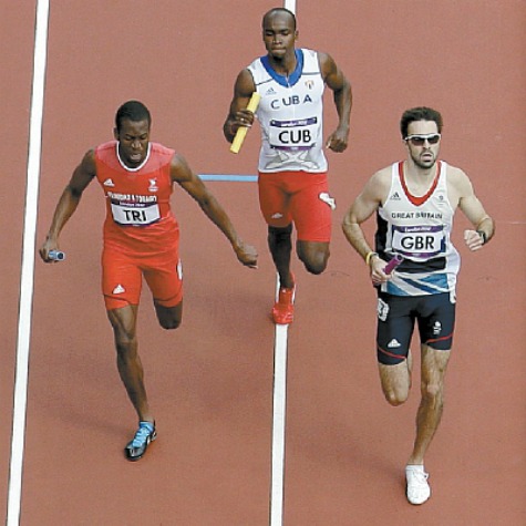 T&T’s Deon Lendore, left, races Cuba’s Omar Cisneros, centre, and Britain’s Martyn Rooney to the finish of a men’s 4 x 400-metre relay heat during the athletics in the Olympic Stadium at the 2012 Summer Olympics, London, yesterday. The T&T quartet took joint first place with Britain in the event. AP Photo