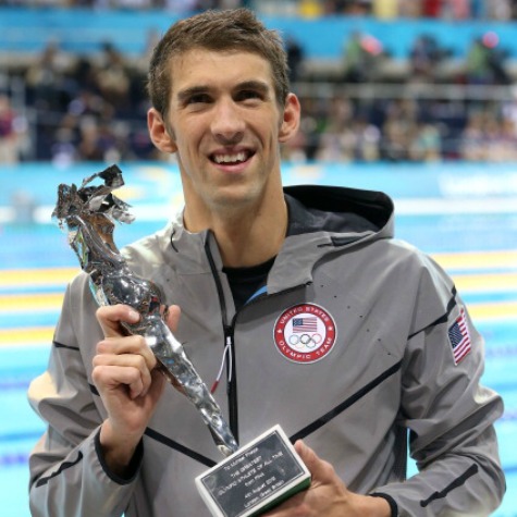 Michael Phelps shows off the trophy proclaiming him as